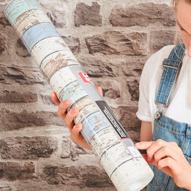 Woman with a roll of wallpaper in her hand
